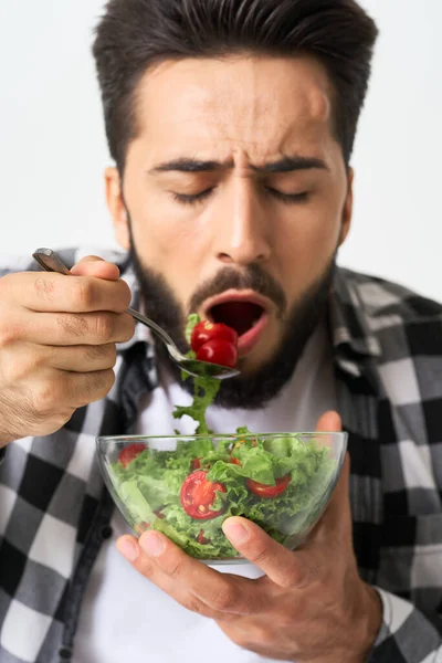 Uomo in camicia a quadri mangiare insalata cibo sano — Foto Stock