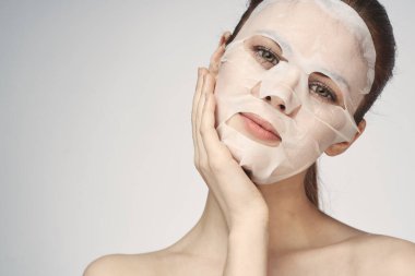 Güzel bir kadın çıplak omuzlarıyla maske takar.