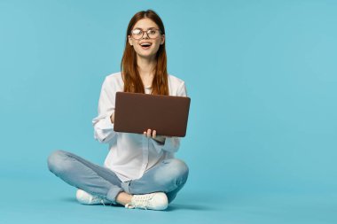 Dizüstü bilgisayarı olan kadın internet eğitimi mavi arka plan