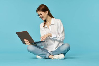 Dizüstü bilgisayarı olan kadın internet eğitimi mavi arka plan
