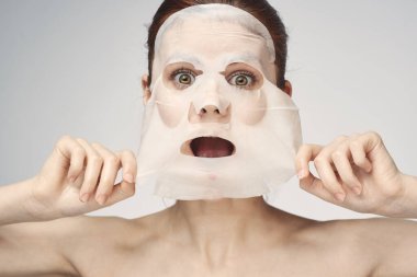 Çıplak omuzlu kadın maske takıyor.