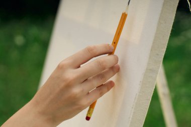 Kalem sehpası çizen kadın eli.