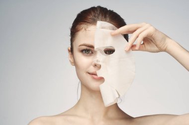 Çıplak omuzlu kadın maske takıyor.