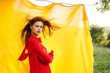 Kırmızı elbiseli duygusal kadın. Sarı arka plan pozu.