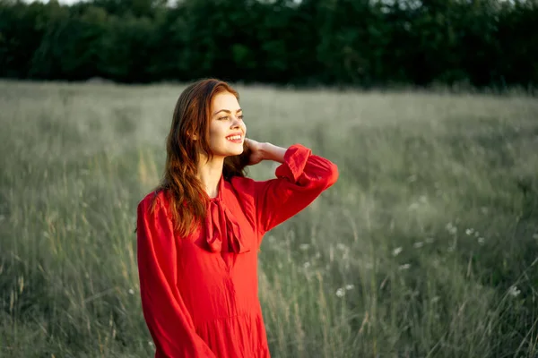 Mulher bonita em vestido vermelho no campo natureza posando paisagem — Fotografia de Stock