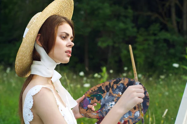 Mujer con una paleta de pinturas pintando un cuadro al aire libre de cerca — Foto de Stock