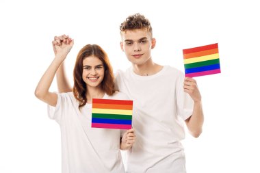 Beyaz tişörtlü genç çift lgbt travesti cinsel azınlıklar bayrağı taşıyor.