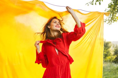 Kırmızı elbiseli neşeli bir kadın elleriyle işaret ediyor.