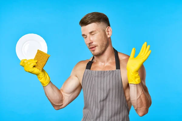 Een man met een opgepompt lichaam met rubberen handschoenen die huiswerk maakt — Stockfoto