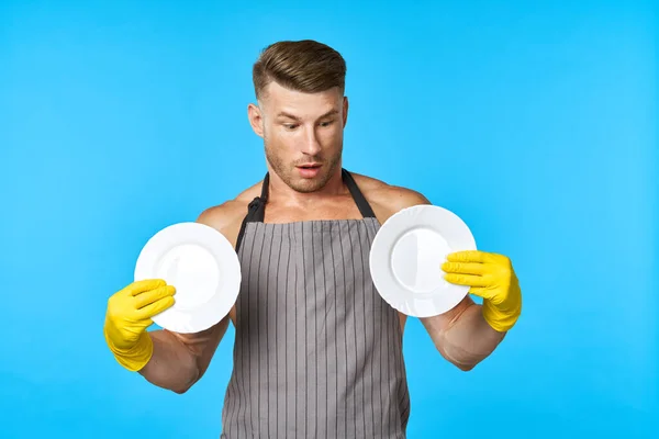 Hombre alegre en delantales lavar los platos de las tareas domésticas fondo azul — Foto de Stock