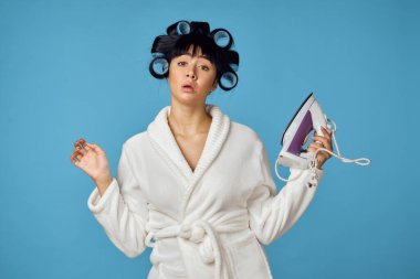 Beyaz cüppeli kadın ev işi temizlik servisi mavi arka plan