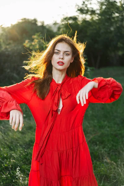 Mulher atraente em vestido vermelho ao ar livre no campo de liberdade — Fotografia de Stock