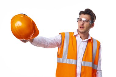 Turuncu üniformalı bir adam inşaat işinde.