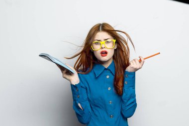 Not defteri ve kalem takan, sarı gözlüklü profesyonel bir iş kadını.