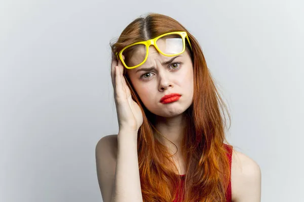 Mooie vrouw geel bril en rode lippen mode licht achtergrond — Stockfoto