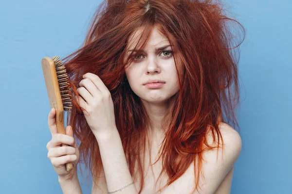 Vrouw met rood haar kam zorg blauwe achtergrond — Stockfoto