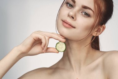 Çıplak omuzlu çekici bir kadın. Salatalık cilt bakımı.