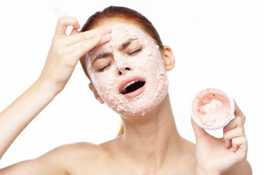 Yüzü maskeli, omuzları açık cilt tazeleme güzelliği olan bir kadın.