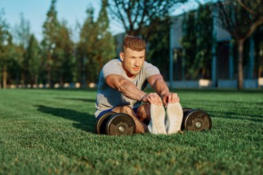 Spor salonunda dambılı olan atletik bir adam.