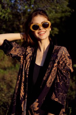 Dışarıda güneş gözlüğü takan bir kadın moda cazibesi sergiliyor.