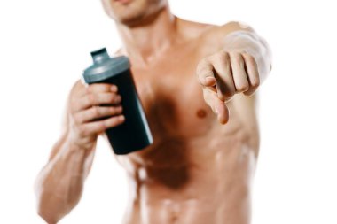 Şişirilmiş gövdesi olan atletik bir adam. Spor tükürüğü şişesi içiyor.