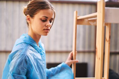 Koruyucu giysi yenileme evindeki kadın ressam