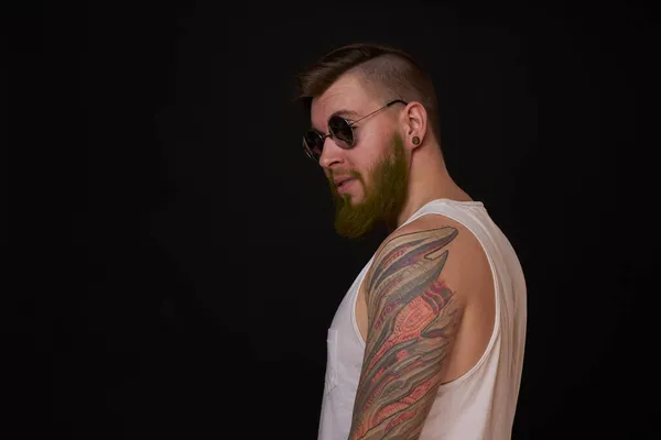 Hombre barbudo en camiseta blanca con tatuajes en sus brazos posando macho —  Fotos de Stock