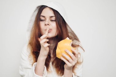 Kızıl saçlı kadın, öğle yemeğinde sandviç yiyor.