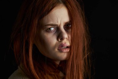 Üzgün kadın ağlıyordu. Gözlerinde morluklar vardı. Karanlık arka plan.