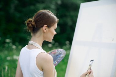 Kadın ressam açık havada yaratıcı manzara çiziyor.