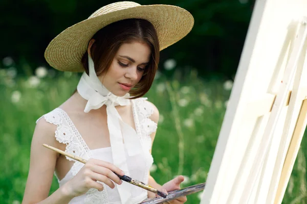 Artista mujer dibuja un cuadro en un caballete al aire libre — Foto de Stock