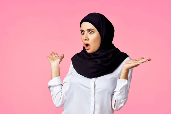 Muslim kvinna med miniräknare och ekonomi pengar rosa bakgrund — Stockfoto