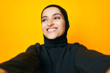 Güzel bir kadın etnik köken modeli duygularını sarı arka planda gösteriyor.