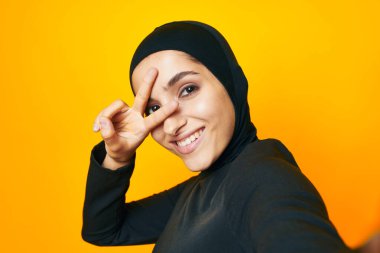 Siyah tesettürlü neşeli kadın moda el hareketi yapıyor izole edilmiş arka plan