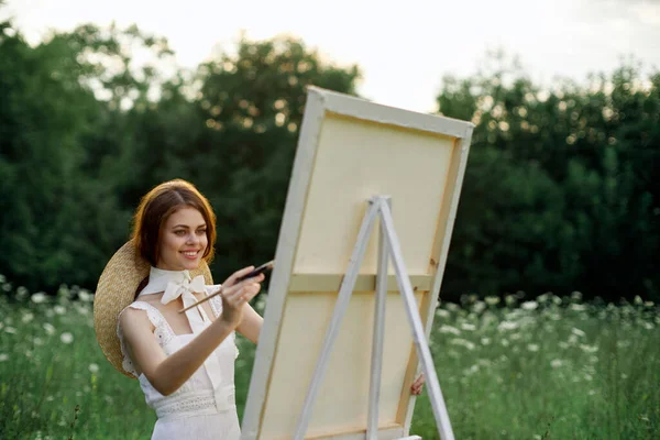 Mujer en vestido blanco pinta una imagen al aire libre hobby creativo —  Fotos de Stock