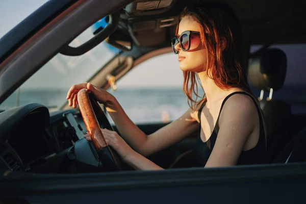 Pretty woman in sunglasses driving a car trip — Stock Photo, Image