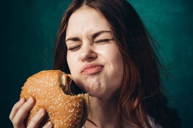 Hamburger yiyen bir kadın.