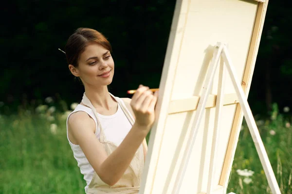 Женщина художник рисует картину возле мольберта на открытом воздухе пейзаж творческий — стоковое фото