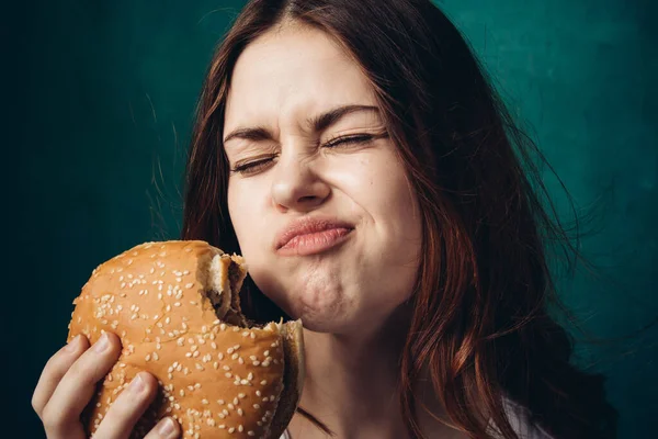 Hamburger yiyen bir kadın.