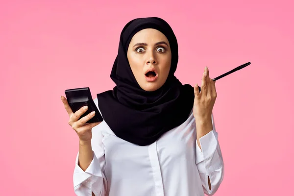 Muslimische Frau mit Taschenrechner und Finanzgeld rosa Hintergrund — Stockfoto