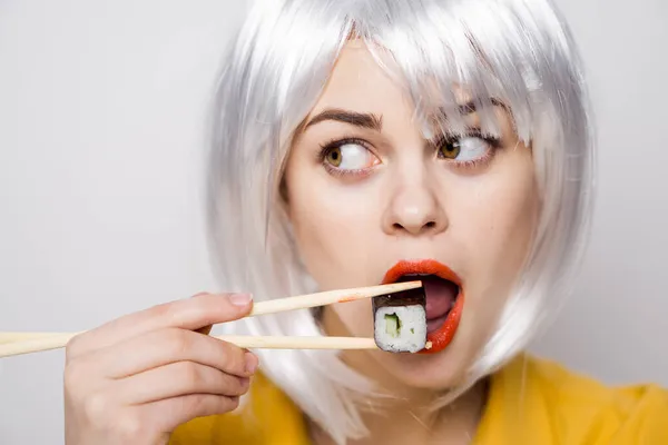 Pretty woman in white wig and sushi with Japanese chopsticks — Stock Photo, Image