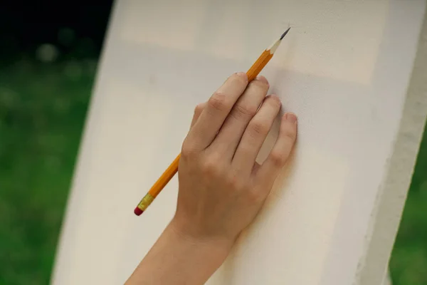 Main féminine avec chevalet crayon dessin de près — Photo