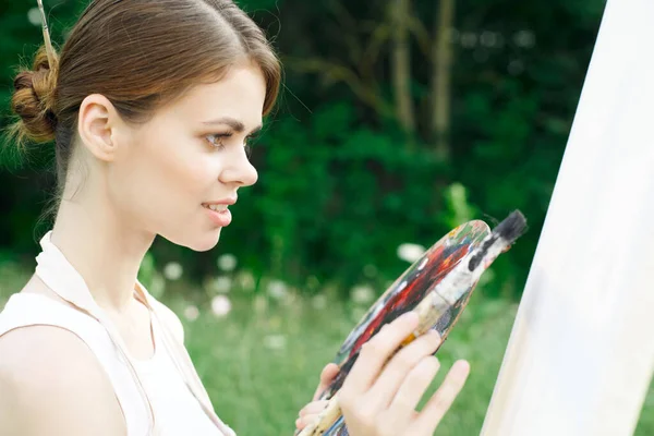 Woman artist paints palette easel nature drawing — Stock Photo, Image