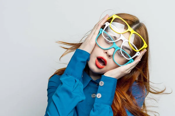 Kvinna med flerfärgade glasögon i ansiktet i blå skjorta poserar glamour — Stockfoto