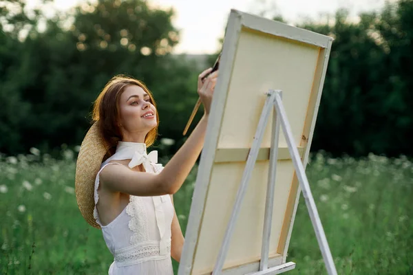 Γυναίκα σε λευκό φόρεμα ζωγραφίζει μια εικόνα σε εξωτερικούς χώρους χόμπι δημιουργική — Φωτογραφία Αρχείου