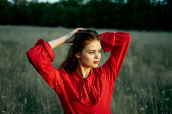 Милая рыжая женщина в красном платье в поле летом природа — стоковое фото