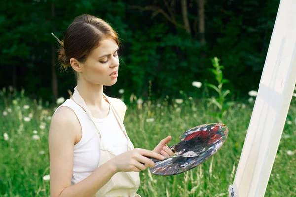 Woman in white dress with palette of paints on nature art drawing — Stock Photo, Image