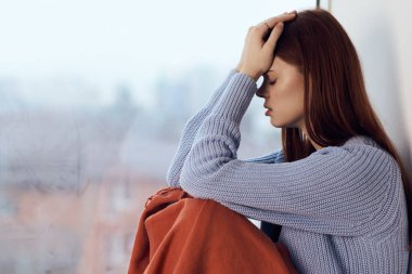 Pencere kenarında oturan kadın ekoseli bir sabah hayatı yaşıyor.