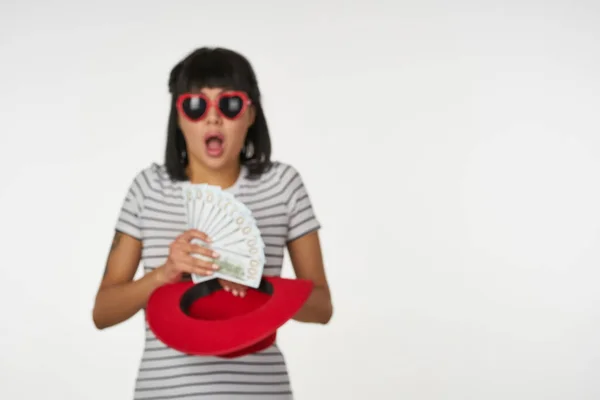 Kvinna i randig t-shirt bär glasögon med pengar i händerna förmögenhet finansiering — Stockfoto