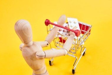 Tahta kukla, sarı arka planda.